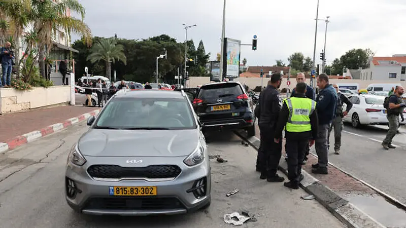Personel darurat dan keamanan Israel berdiri di samping mobil yang rusak usai serangan teroris di pusat Kota Raanana, pada 15 Januari 2024. (Jack Guez / AFP)
