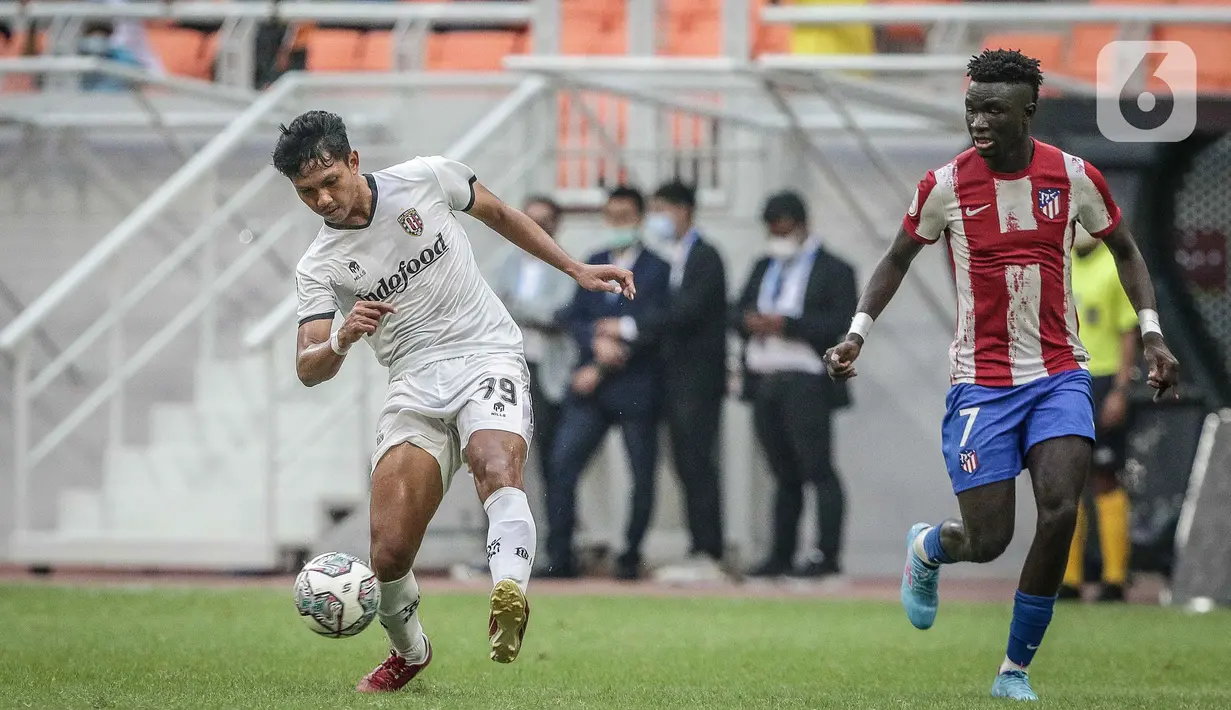 Pemain Bali United U-18 I Made Dwi Meiyana Putra berebut bola dengan pemain Atletico Madrid U-18 Ninte Nater Carungal pada laga perdana International Youth Championship (IYC) 2021 di Jakarta International Stadium (JIS), Rabu (13/4/2022). Atletico Madrid U-18 menang 5-0. (Liputan6.com/Faizal Fanani)
