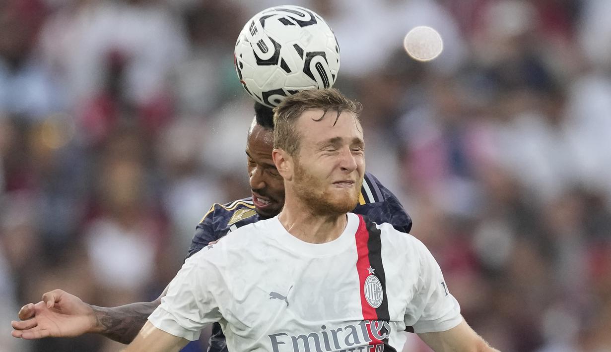 Gelandang AC Milan, Tommaso Pogeba (depan) berduel udara dengan bek Real Madrid, Eder Militao pada laga pramusim 2023/2024 Soccer Champions Tour di Rose Bowl Stadium, Pasadena, California, Senin (24/7/2023) pagi WIB. (AP Photo/Ashley Landis)