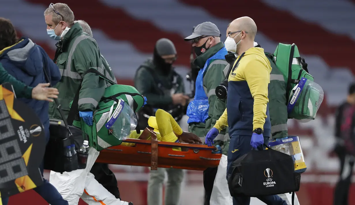 Gelandang Villarreal, Samuel Chukwueze ditandu keluar lapangan usai mengalami cedera saat melawan Arsenal dalam laga leg kedua semifinal Liga Europa 2020/2021 di Emirates Stadium, London, Kamis (6/5/2021). Villarreal bermain imbang 0-0 dengan Arsenal. (AP/Alastair Grant)
