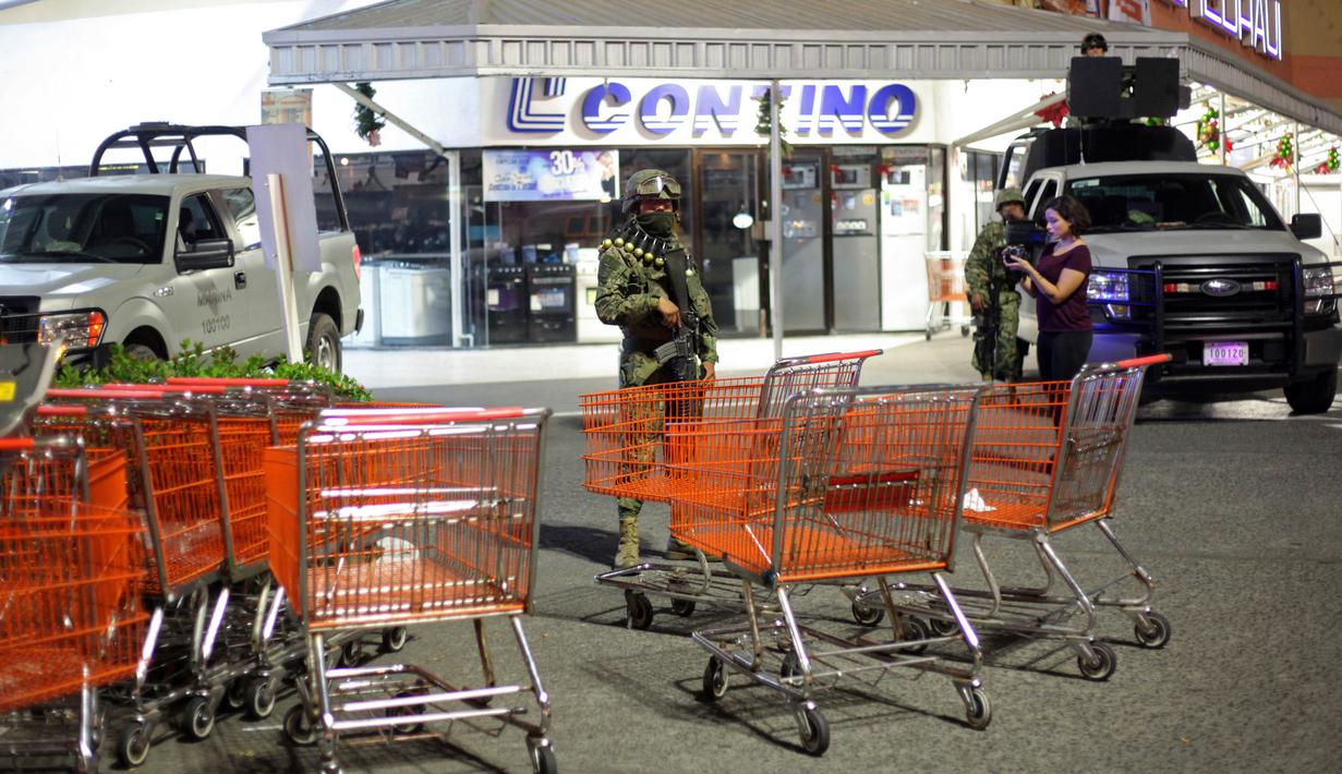 Polisi marinir berjaga di super market usai penjarahan di pelabuhan Veracruz, Meksiko, (4/1). Kepolisian menyebut sebanyak 300 toko digeledah dan lebih dari 600 orang ditangkap. (AP Photo/Felix Marquez)