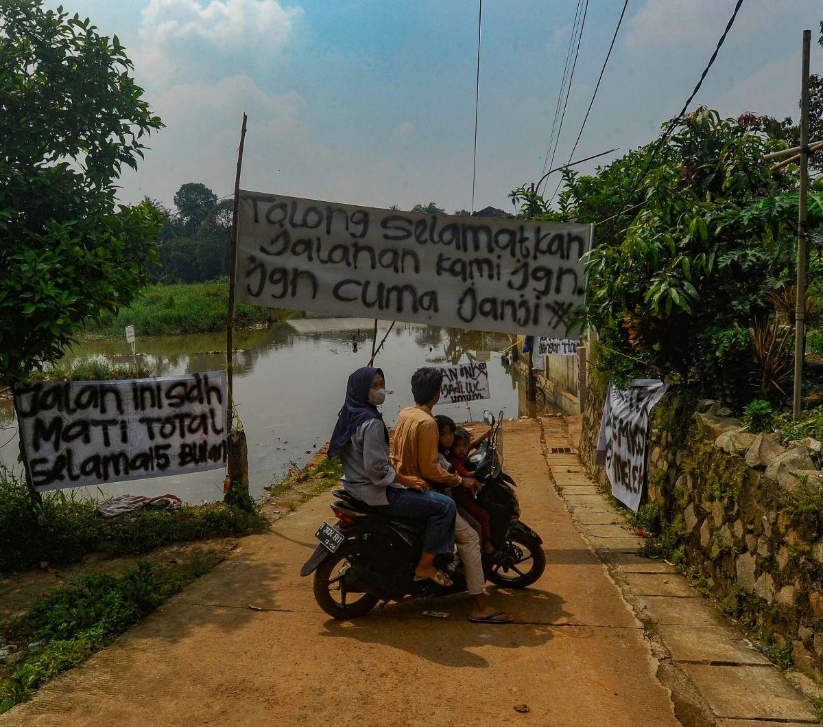 Warga memutar sepeda motornya ketika banjir akibat longsor TPA Cipayung merendam jalanan di Depok, Jawa Barat, Selasa (30/4/2024). Sudah lebih dari satu tahun, sampah di TPA Cipayung yang overload longsor dan menimbun sebagian badan Kali Pesanggrahan.&nbs