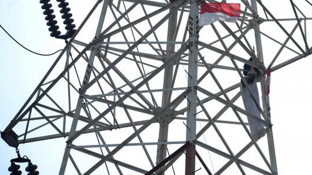 Pria berpakaian pocong di atas tower SUTET