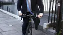 Mantan Wali Kota London, Boris Johnson menggunakan sepeda saat akan meninggalkan rumahnya di London , Inggris, (21/6). Ia merupakan anggota kelompok dari Vote Leave campaign atau kelompok yang ingin Inggris keluar dari PBB. (REUTERS / Peter Nicholls)