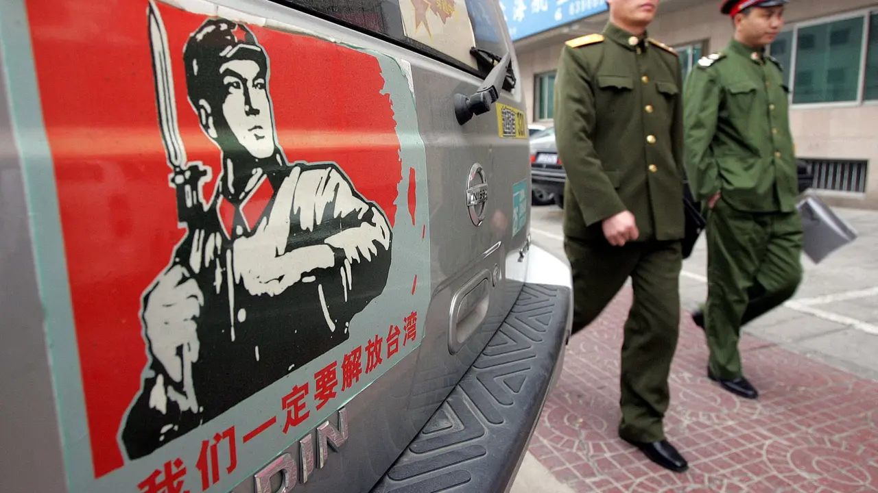Tentara melewati sebuah stiker yang menampilkan wilayah China bersatu dengan Taiwan (AP Photo)