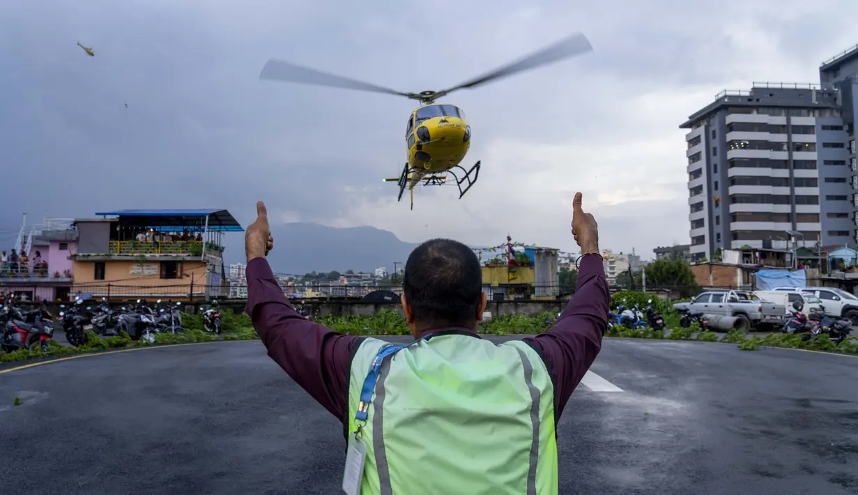 Sebuah helikopter yang membawa jenazah korban kecelakaan helikopter tiba di Kathmandu, Nepal, Selasa, 11 Juli 2023. (AP Photo/Niranjan Shrestha)