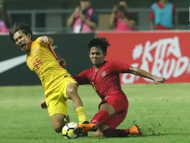 Bek Timnas Indonesia U-19, Firza Andika (kanan) berebut bola dengan pemain China U-19, Qinhan Sun pada laga PSSI 88th U-19 International Tournament di Stadion Pakansari, Cibinong, Selasa (25/9). Indonesia kalah 0-3. (Liputan6.com/Helmi Fithriansyah)