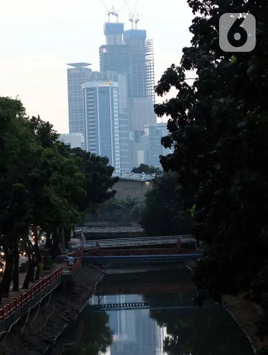 Refleksi pembangunan gedung bertingkat di kawasan Kuningan, Jakarta, Rabu (8/7/2020). Wabah Covid-19 memengaruhi kondisi kesejahteraan masyarakat dan pertumbuhan ekonomi Indonesia pada tahun 2020 yang diproyeksikan -0,4 sampai dengan 1,0 persen. (Liputan6.com/Helmi Fithriansyah}