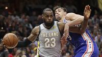 Bintang Cleveland Cavaliers, LeBron James mencoba melewati hadangan pemain Philadelphia 76ers, Dario Saric. (AP Photo/Tony Dejak)