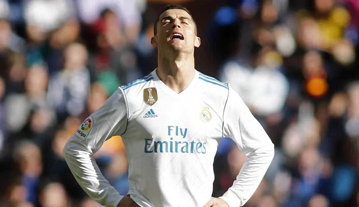 Striker Real Madrid, Cristiano Ronaldo, tampak kecewa usai ditaklukkan Barcelona pada laga bertajuk El Clasico La Liga di Santiago Bernabeu, Sabtu (23/12/2017). Real Madrid takluk 0-3 dari Barcelona. (AFP/Oscar Del Pozo)