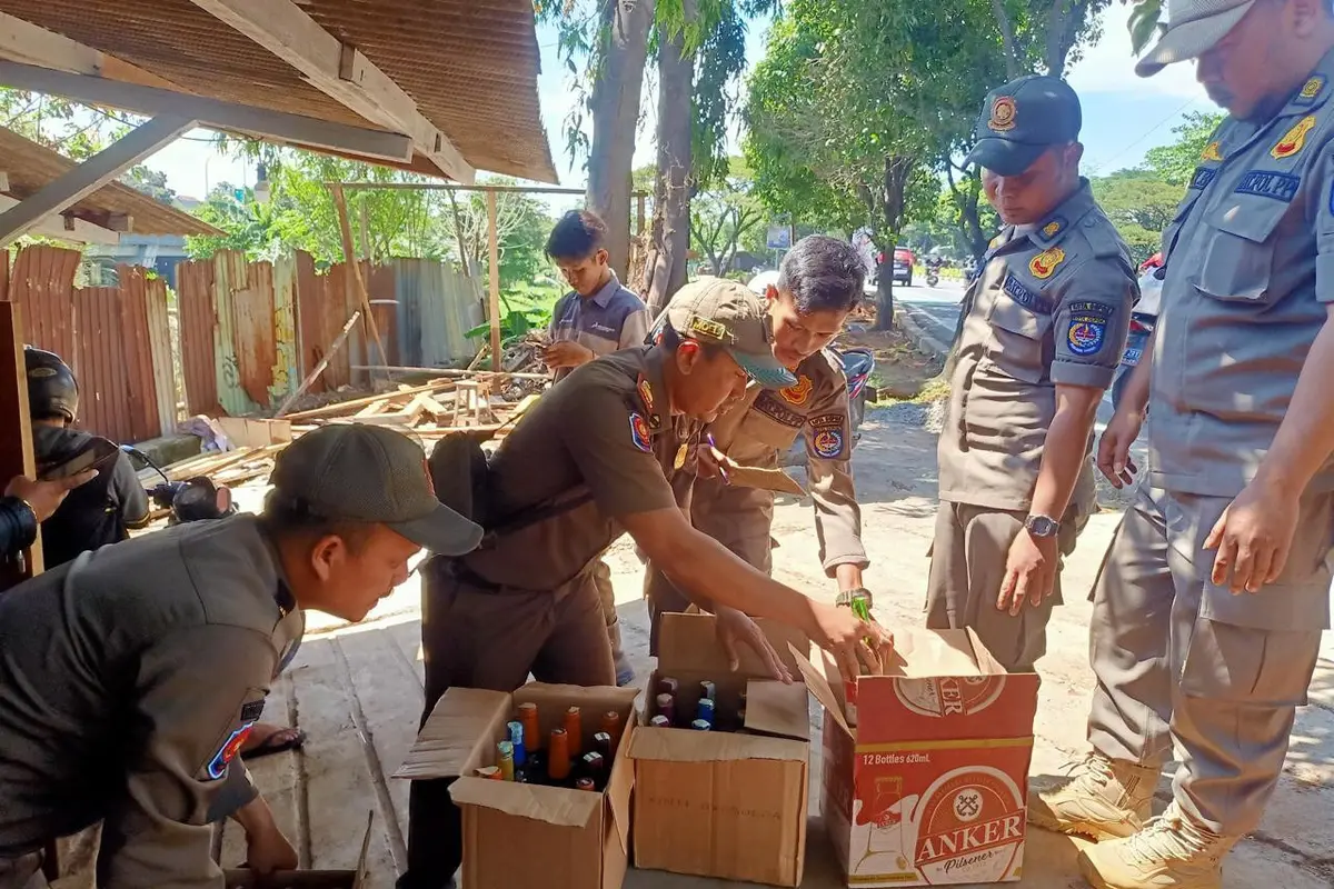 Anggota Satpol PP Kota Depok menyita puluhan botol miras dari sebuah warung di Jalan Raya Juanda, Sukmajaya, Depok.