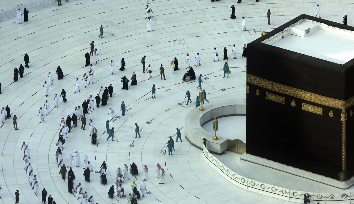 <p>Pekerja melakukan disinfeksi untuk membantu mengekang penyebaran virus corona COVID-19 saat jemaah umrah tawaf mengelilingi Ka'bah pada awal bulan suci Ramadhan di Masjidil Haram, Mekkah, Arab Saudi, Senin (12/4/2021). (AP Photo/Amr Nabil)</p>
