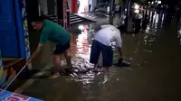 Warga terlihat berjibaku membersihkan lingkungannya yang terdampak banjir di lokasi banjir wilayah Kelurahan Cepu, Kecamatan Cepu, Kabupaten Blora. (Liputan6.com/Ahmad Adirin)