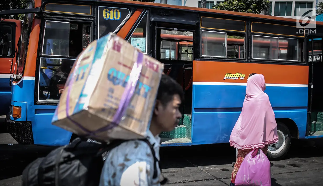 Sejumlah penumpang melintas diantara Metromini di Terminal Blok M, Jakarta, Rabu (26/7). Dinas Perhubungan (Dishub) DKI Jakarta akan merevitalisasi 700 unit metromini menjadi Minitrans. (Liputan6.com/Faizal Fanani)