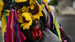 Seorang pria berpakaian "bolero" menjulurkan lidahnya saat merayakan Hari Suci Tak Bersalah yang memperingati pembunuhan bayi laki-laki oleh Raja Herodes di Betlehem setelah kelahiran Yesus menurut Injil Matius, di Caucagua, Venezuela, Selasa (28/12/2021). (AP Photo/Matias Delacroix)