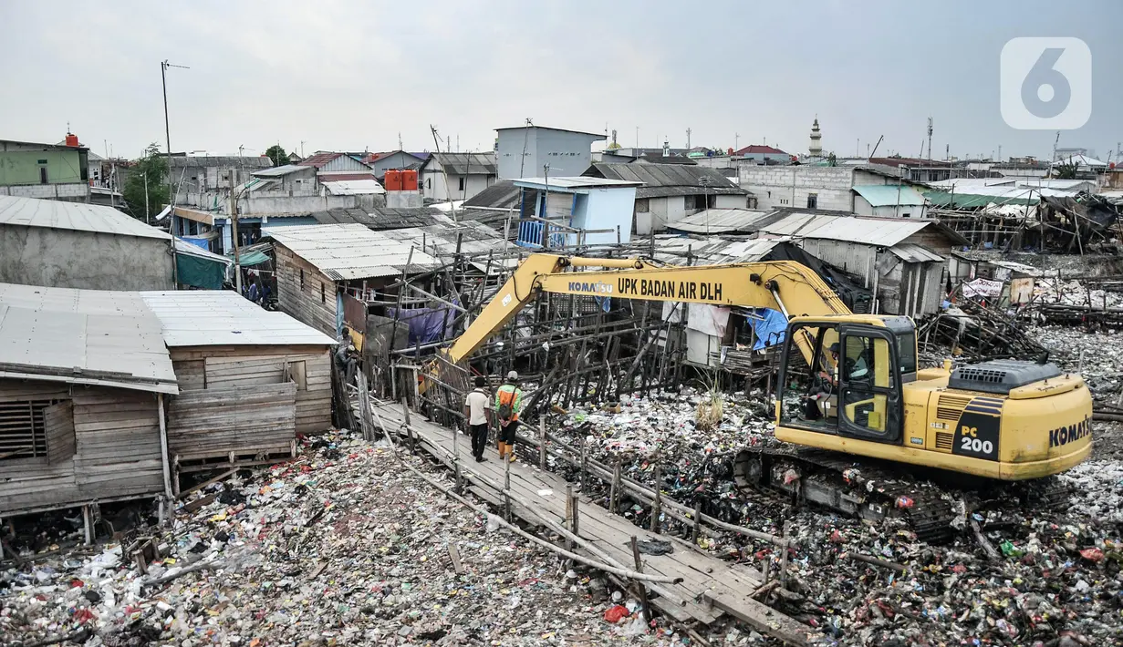 Pekerja Suku Dinas Lingkungan Hidup Kepulauan Seribu menggunakan alat berat saat membersihkan sampah di kawasan Kali Baru, Cilincing, Jakarta Utara, Rabu (23/2/2022). Pembersihan dilakukan menyusul menumpuknya sampah di kampung tempat nelayan bermukim tersebut. (merdeka.com/Iqbal S. Nugroho)