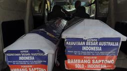 Petugas Kantor Pos mengirimkan dua peti mati ke kantor Kedutaan Besar Australia untuk Indonesia di Rasuna Said, Jakarta, Senin (9/3/2015).  Tampak, dua peti mati kiriman Bambang Saptono saat masih berada di dalam mobil. (Liputan6.com/Andrian M Tunay)