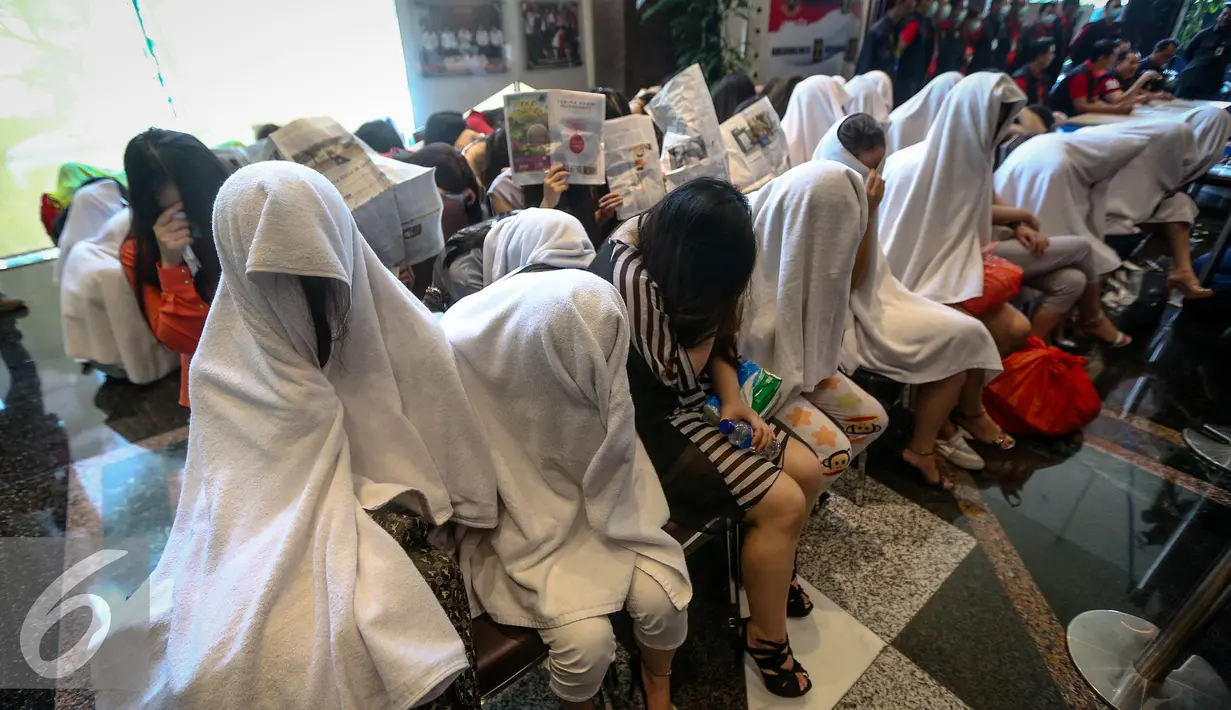 Sejumlah Warga Negara Asing diamankan petugas di Direktorat Jenderal Imigrasi, Jakarta, Minggu (1/1). Dalam oprasi tersebut ditemukan sejumlah barang bukti, seperti paspor, uang tunai, alat kontrasepsi, dan pakaian dalam. (Liputan6.com/Faizal Fanani)