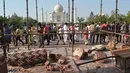Wisatawan berkumpul di sekitar royal gate atau gerbang kerajaan setelah pilar Taj Mahal runtuh diterpa angin kencang di Agra, India, Kamis (12/4). Dua pilar Taj Mahal yang roboh diterpa angin kencang itu terdapat di gerbang masuk yang berbeda. (AFP Photo)