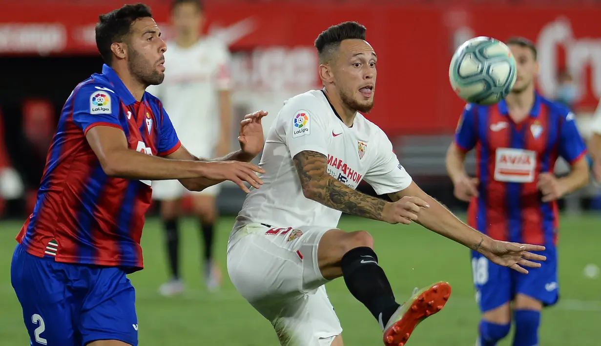 Gelandang Sevilla, Lucas Ocampos, berebut bola dengan bek Eibar, Esteban Burgos, pada laga lanjutan La Liga pekan ke-34 di Estadio Ramon Sanchez Pizjuan, Selasa (7/7/2020) dini hari WIB. Sevilla menang 1-0 atas Eibar. (AFP/Cristina Quicler)