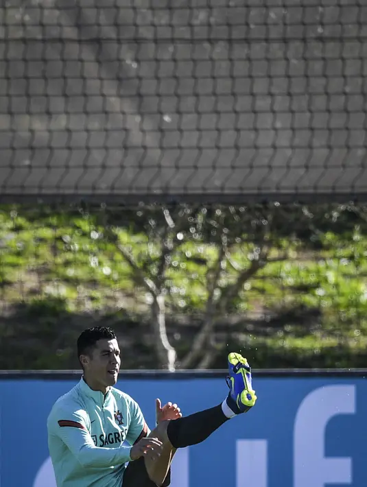Penyerang Portugal, Cristiano Ronaldo melakukan pemanasan selama sesi latihan di tempat latihan Cidade do Futebol di Oeiras (10/11/2021). Portugal akan bertanding melawan Irlandia pada Grup A kualifikasi Piala Dunia 2022  di Aviva Stadium. (AFP/Patricia De Melo Moreira)