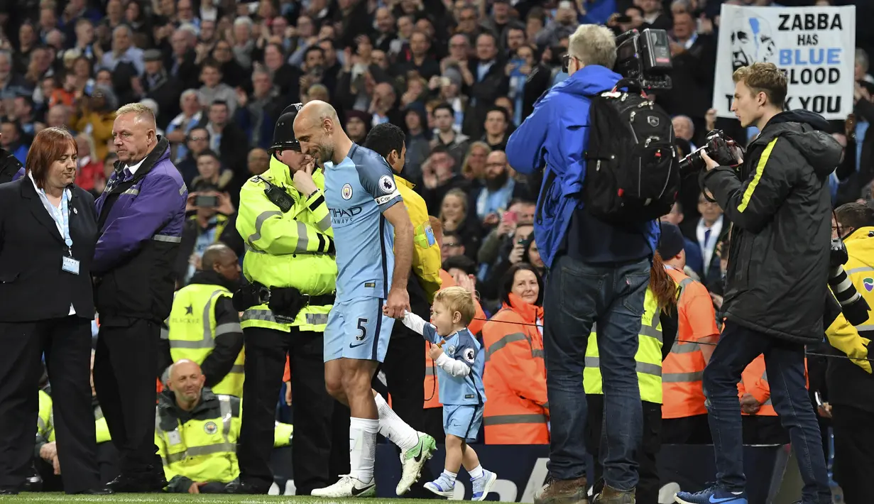 Bek Manchester City, Pablo Zabaleta, bersama anaknya usai pertandingan Liga Inggris melawan West Bromwich Albion di Stadion Etihad, Selasa, (16/05/2017). Zabaleta resmi pamit dari klub Manchester City. (AFP/Anthony Devlin)