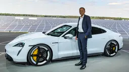 CEO Porsche, Oliver Blume, berdiri di sebelah mobil elektrik Porsche, Taycan selama world premiere di bandara Neuhardenberg, dekat Berlin, Rabu (4/9/2019). Mobil listrik dengan model Saloon Sport 4 pintu itu disebut menawarkan ketangguhan namun bisa dipakai sehari-hari. (Patrick Pleul/dpa via AP)