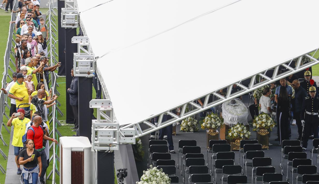 Warga berbondong-bondong ke markas Santos untuk memberikan penghormatan terakhir kepada legenda sepakbola Brasil, Pele. (AP Photo/Matias Delacroix)