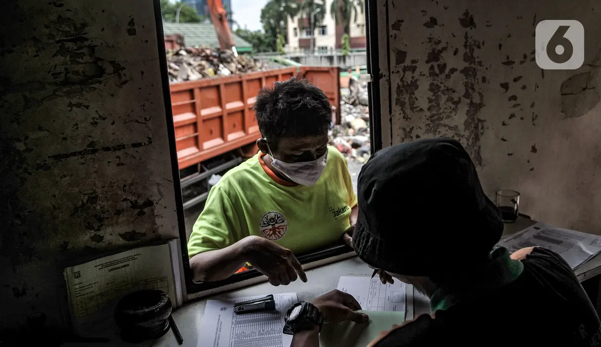 Petugas mendata sampah sungai yang diangkut saat tiba di TPSS Perintis Kemerdekaan, Jakarta, Selasa (16/2/2021). Selama musim hujan, volume sampah yang diangkut dari sungai di Jakarta meningkat hingga 600 meter kubik per hari. (merdeka.com/Iqbal S. Nugroho)