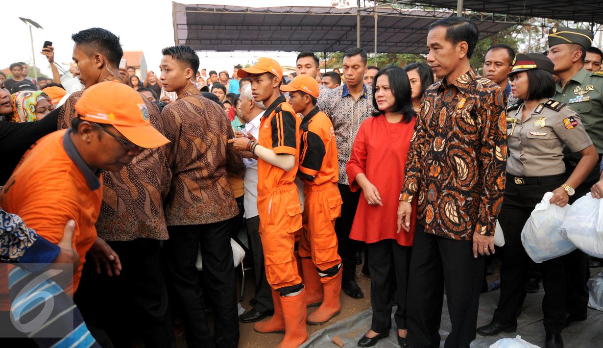 Presiden RI Joko Widodo besertaibu Iriana melihat langsung proses pembagian paket sembako kepada warga di sekitar Lapangan Bedeng, Pisangan Baru, Jakarta, Selasa (8/9/2015). (Liputan6.com/Helmi Fithriansyah)
