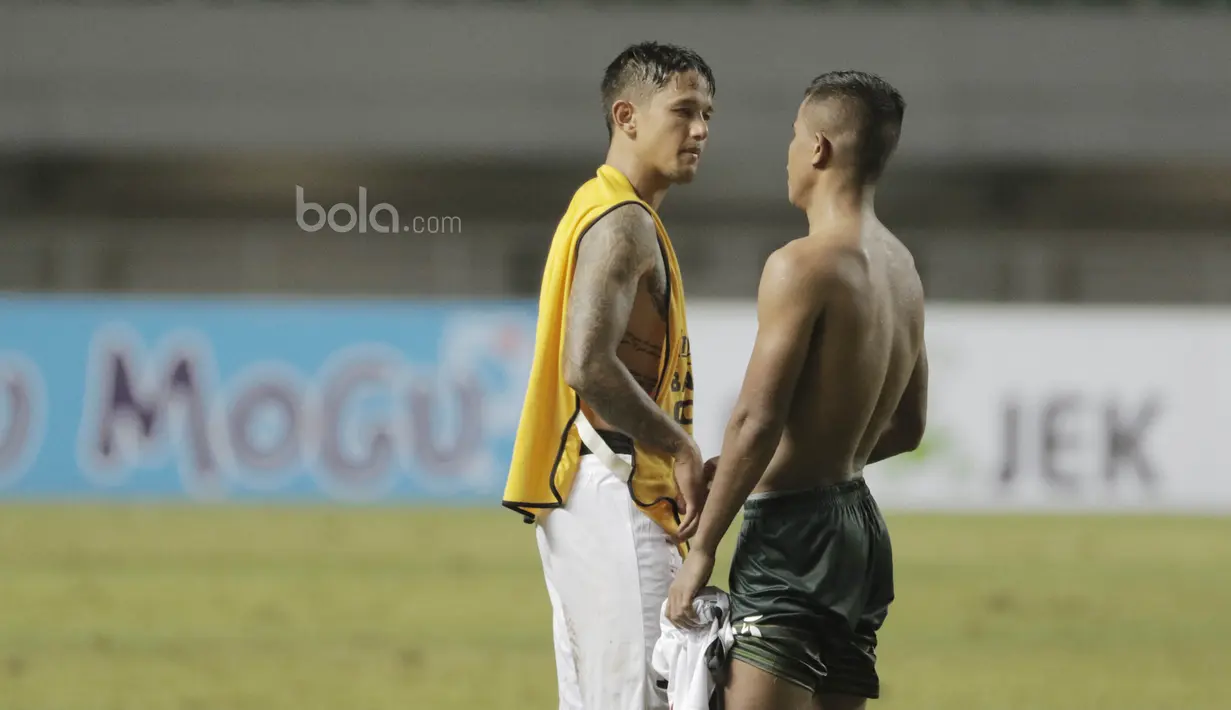 Striker Bali United, Irfan Bachdim, berbincang dengan gelandang PS TNI, Manahati Lestusen pada laga lanjutan Liga 1 di Stadion Pakansari, Bogor, Senin (10/7/2017). (Bola.com/M Iqbal Ichsan)