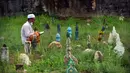 Seorang pria berdoa di sebelah makam kerabat saat perayaan Hari Raya Idul Adha di sebuah pemakaman di Provinsi Narathiwat, Thailand, Rabu (21/7/2021). Setiap Idul Adha atau hari besar Islam lainnya, sebagian warga banyak mendatangi kuburan untuk mendoakan keluarganya. (Madaree TOHLALA/AFP)