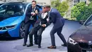 Dua orang tampak membantu CEO BMW, Harald Krueger yang jatuh pingsan saat sedang presentasi selama Frankfurt Motor Show (IAA) di Jerman, Selasa (15/9). Krueger jatuh ketika tengah memberikan ulasan mengenai produk terbaru BMW. (REUTERS/Kai Pfaffenbach)