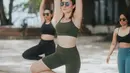 Melihat potret body goals Wulan Guritno saat yoga. Ia memilih mengenakan sport wear berwarna hijau dan sunglasses. [Foto: Instagram/wulanguritno]
