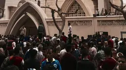 Orang-orang berkumpul di luar Gereja Kristen Koptik St. George, Kota Tanta, utara Kairo, setelah ledakan bom, Minggu (9/4). Serangan bom di dua gereja koptik Mesir itu menewaskan sedikitnya 45 orang dan puluhan lainnya terluka. (AP Photo/Nariman El-Mofty)