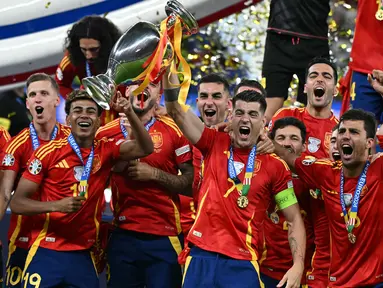 Penyerang Spanyol, Alvaro Morata (tengah) mengangkat trofi saat merayakannya gelar juara Euro 2024 di Olympiastadion, Berlin pada 14 Juli 2024 atau Senin 15 Juli 2024 dini hari WIB. (JAVIER SORIANO/AFP)