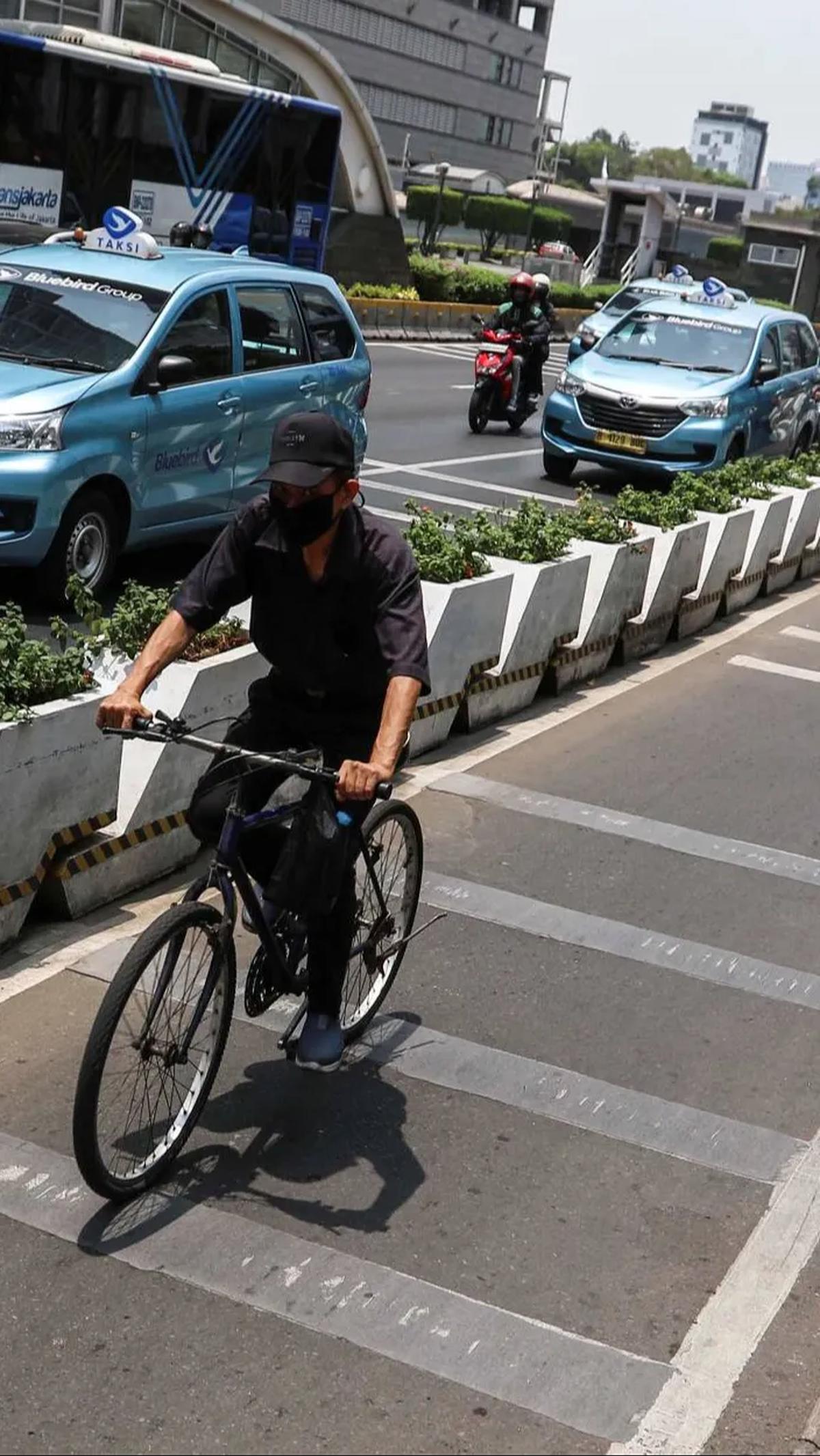 Pengendara sepeda melintasi pada jalurnya saat fenomena Kulminasi Utama.