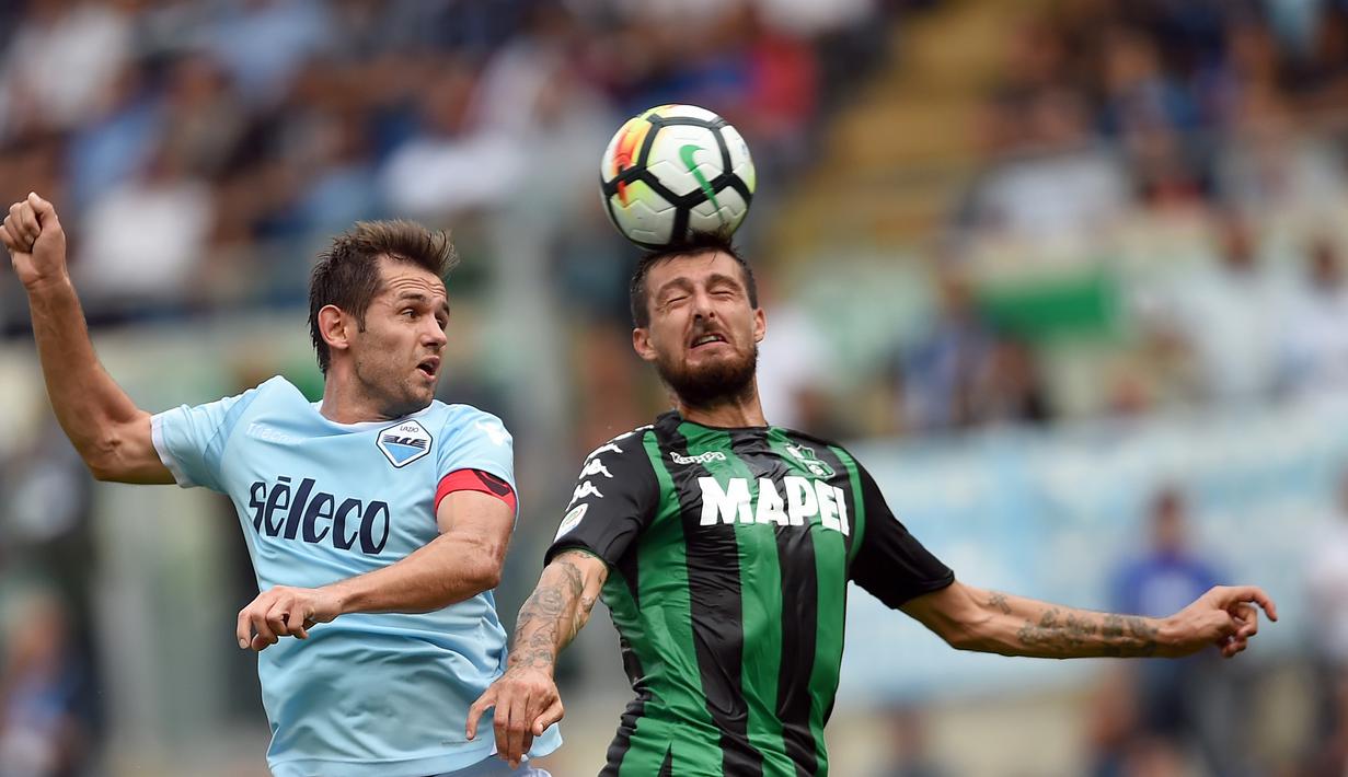 Duel pemain Lazio, Senad Lulic (kiri)  dengan pemain Sassuolo, Francesco Acerbi pada lanjutan Serie A di Olympic Stadium, Roma, (1/10/2017). Lazio menang telak 6-1. (AFP/Filippo Monteforte)