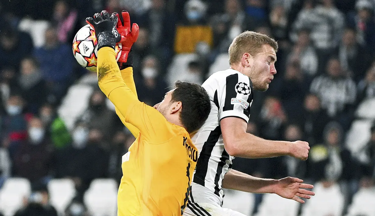 Kiper Zenit St. Petersburg, Stanislav Kritsyuk berebut bola dengan bek Juventus, Matthijs de Ligt pada match day ke-4 Liga Champions di Allianz stadium, Rabu (3/11/2021) dinihari WIB. Menjamu Zenit, Juventus menang 4-2 atas Zenit. (Marco Alpozzi/LaPresse via AP)