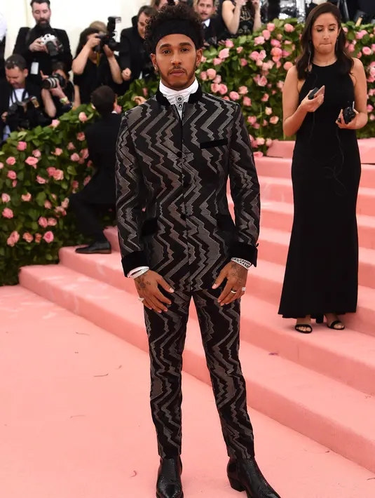 Pembalap Mercedes, Lewis Hamilton berpose saat tiba menghadiri Met Gala 2019 di Metropolitan Museum of Art di New York, AS (6/5/2019). (AFP Photo/Jamie McCarthy)