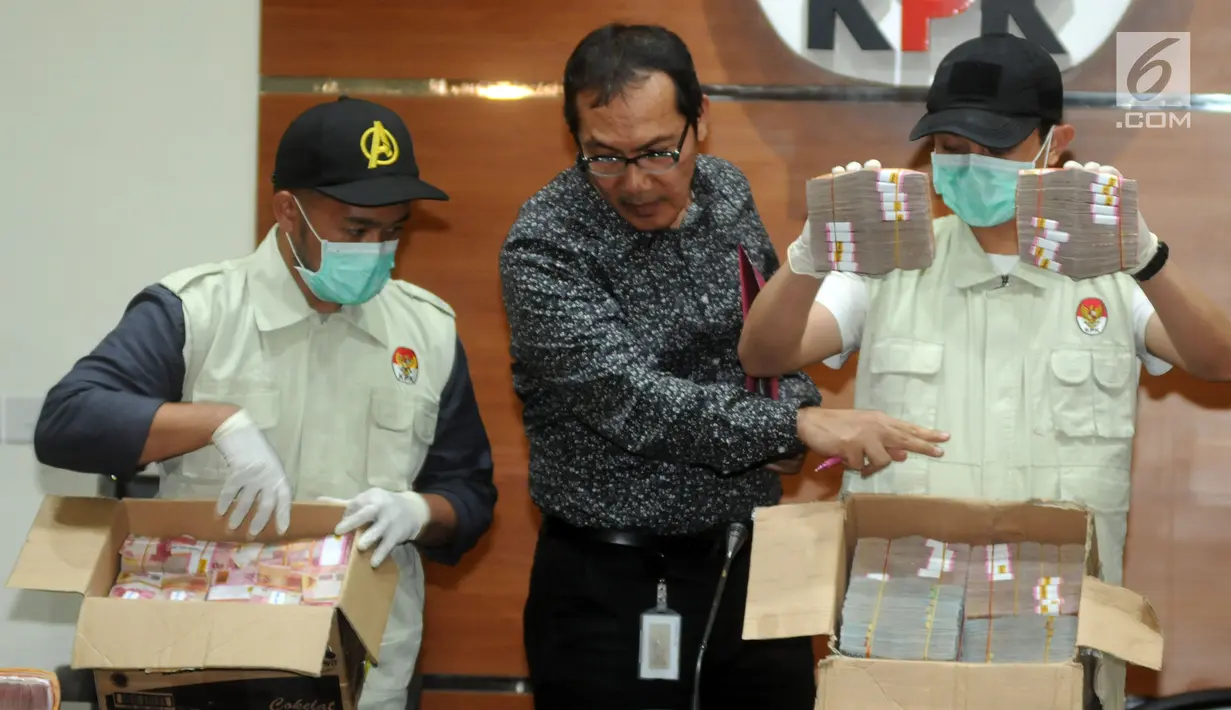 Wakil Ketua KPK Saut Situmorang bersama petugas bersiap menunjukkan barang bukti uang 2,5 Miliar hasil OTT di dua wilayah Kota Blitar dan Kabupaten Tulungagung, Jakarta, Jumat (9/6). (Merdeka.com/Dwi Narwoko)