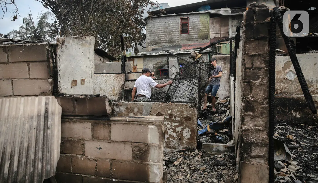 Warga mencari barang berharga di sekitar puing-puing bangunan tempat tinggal mereka yang terbakar di Jalan Tanah Abang 5 RT 003,004/RW 003, Petojo Selatan, Gambir, Jakarta Pusat, Senin (27/2/2023). Adapun situasi dan status kebakaran pada pukul 21.47 WIB, Minggu 26 Februari 2023 dalam proses pendinginan (kuning) yang telah berlangsung sejak 21.20 WIB. (Liputan6.com/Faizal Fanani)
