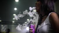 Pecinta Vape atau rokok elektrik sedang mencoba keunggulan alat dan rasa liquid di stand Vape Fair 2016 di Ecovention Hall Ancol, Jakarta, Minggu (27/11). (Liputan6.com/Faizal Fanani)