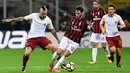 Gelandang AC Milan Hakan Calhanoglu berebut bola dengan gelandang  AS Roma Radja Nainggolan dalam laga lanjutan Serie A pekan ke-7 di San Siro, Minggu (1/10). Roma mampu mempermalukan Milan dengan skor 2-0. (MIGUEL MEDINA/AFP)