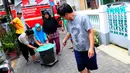 Warga bergotong royong mendorong ember saat pembagian bantuan air bersih di Jalan Kakap Raya, Tanggerang, Senin (17/8/2015). Dalam beberapa hari terakhir, warga Tangerang dan sekitarnya kesulitan mendapatkan air bersih. (Liputan6.com/Faizal R Syam)