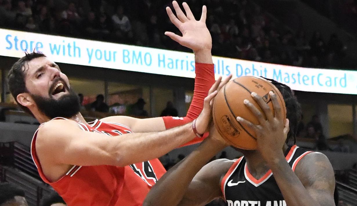 Pebasket Chicago Bulls, Nikola Mirotic, berusaha menghadang pebasket Portland Trail Blazers, Al-Farouq Aminu, pada laga NBA di Stadion United Center, Selasa (2/1/2018). Bulls kalah dari Blazers dengan skor 120-124. (AP/David Banks)