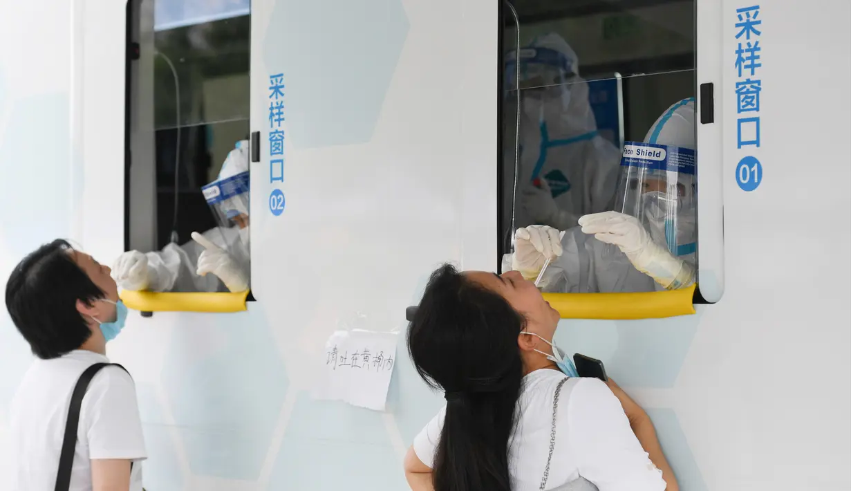 Petugas medis mengambil sampel usap tenggorokan sejumlah warga dari sebuah kendaraan tes mobile yang baru diadopsi di Distrik Xicheng, Beijing, China, Minggu (28/6/2020). (Xinhua/Ju Huanzong)