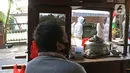 Petugas gabungan dari Kecamatan Cilandak mengarak instalasi peti mati jenazah Covid-19 di kawasan perumahan Fatmawati, Jakarta, Jumat (28/8/2020). Sosialisasi tersebut dilakukan untuk memberikan peringatan kepada warga akan bahaya penularan virus Covid-19. (Liputan6.com/Herman Zakharia)