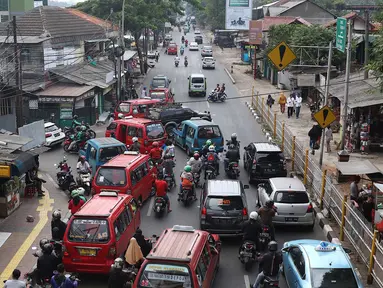 Kendaraan terjebak kemacetan saat melintas di kawasan Lenteng Agung, Jakarta Selatan, Minggu (23/9). Kurang tegasnya petugas menertibkan angkot yang mengetem sembarangan memperparah kemacetan di kawasan tersebut. (Liputan6.com/Immanuel Antonius)