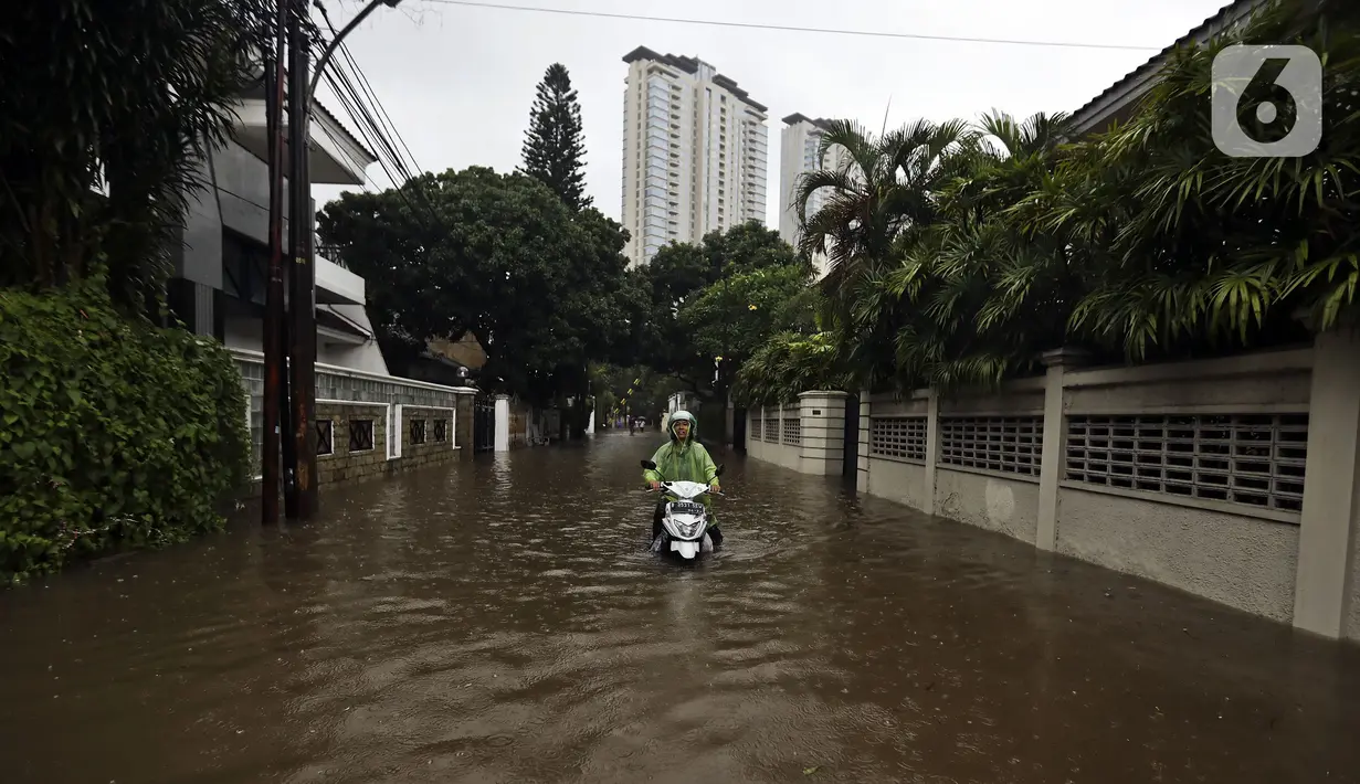 Pengendara motor melintasi banjir di Jalan Hang Lekir, Kebayoran Lama, Jakarta Selatan, Rabu (1/1/2020). Banjir tersebut disebabkan karena tingginya intensitas hujan yang mengguyur sejak Selasa (31/12/2019). (Liputan6.com/Johan Tallo)